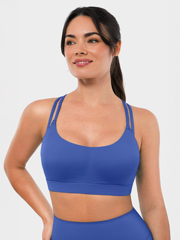 A model wearing a BRXL® BrxlZero™ Cross Back Strappy Sports Bra in Blue / XS