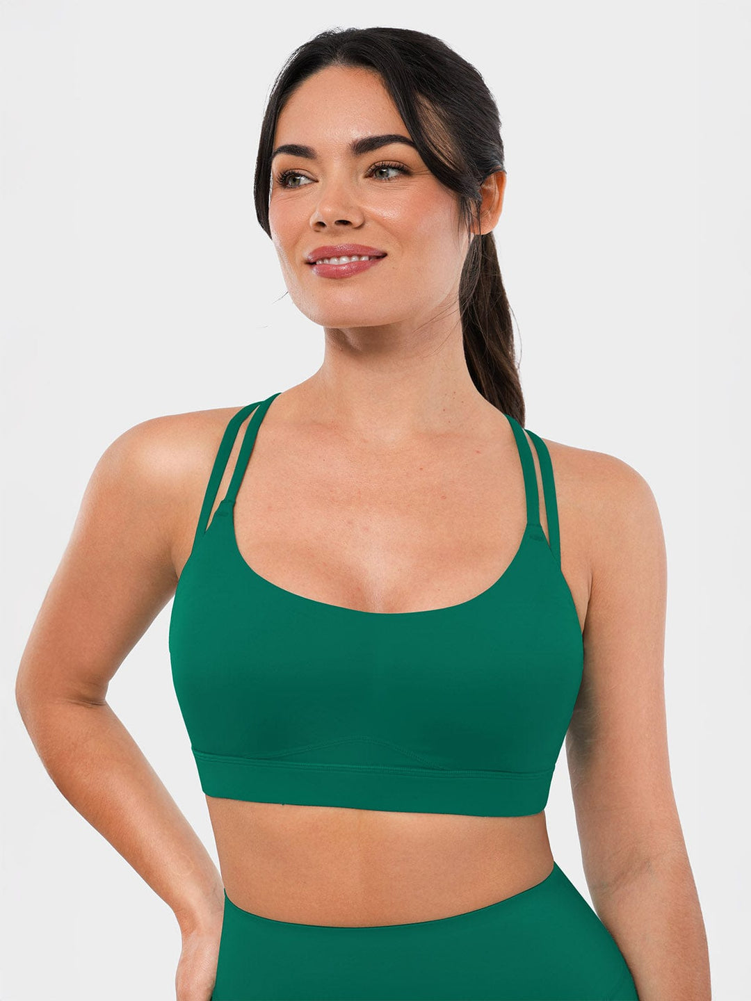 A model wearing a BRXL® BrxlZero™ Cross Back Strappy Sports Bra in Green / XS
