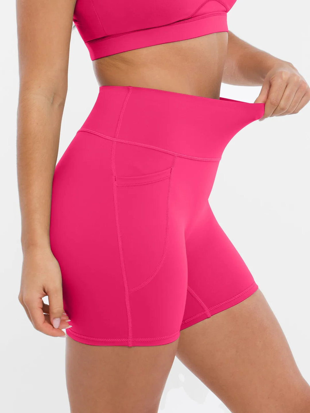 A model wearing a BRXL® Cross Strap Sports Bra High-Waisted Shorts Set in