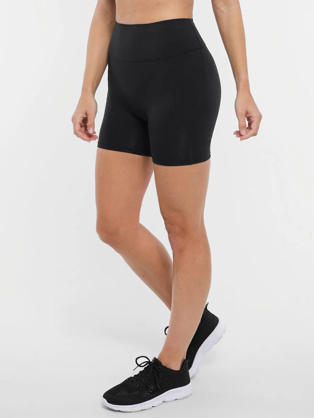 A model wearing a BRXL® Cross Strap Sports Bra High-Waisted Shorts Set in