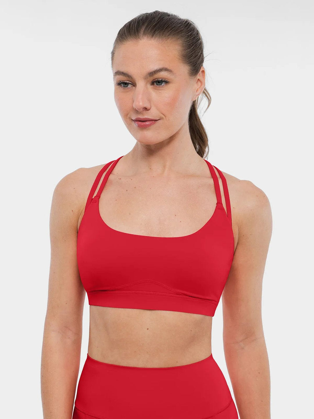 A model wearing a BRXL® Cross Strap Sports Bra High-Waisted Shorts Set in