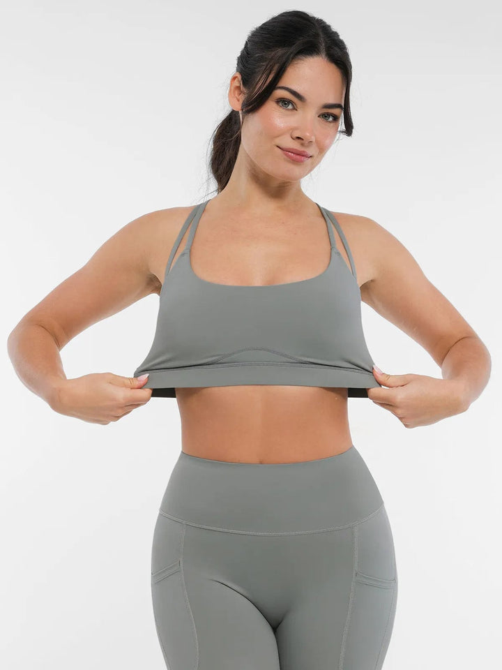 A model wearing a BRXL® Cross Strap Sports Bra High-Waisted Shorts Set in