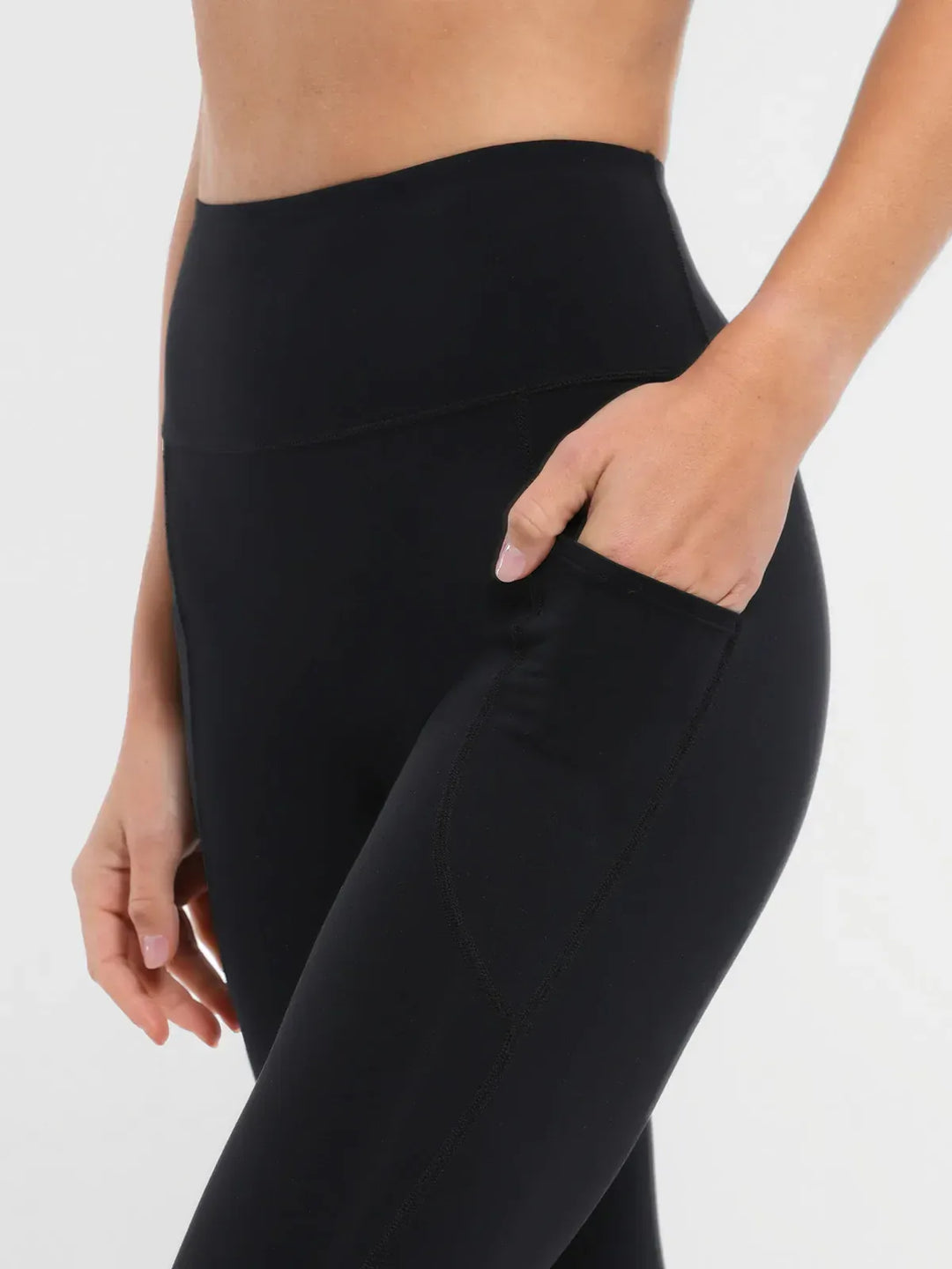 A model wearing a BRXL® Cross Strap Sports Bra Sculpted Leggings Set in