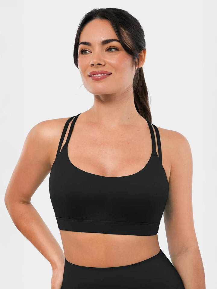 A model wearing a BRXL® Cross Strap Sports Bra Sculpted Leggings Set in Bra / Black / XS
