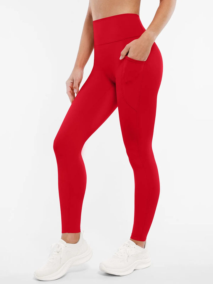 A model wearing a BRXL® Cross Strap Sports Bra Sculpted Leggings Set in Leggings / Red / XS