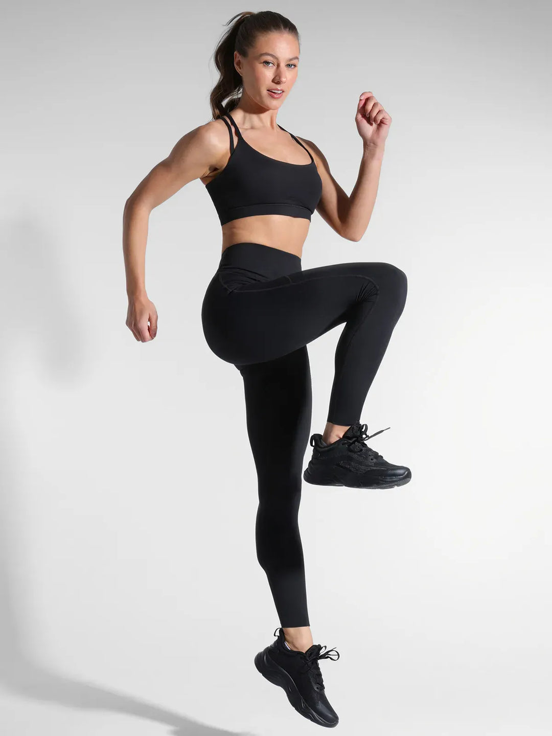 A model wearing a BRXL® Cross Strap Sports Bra Sculpted Leggings Set in Set / Black / XS