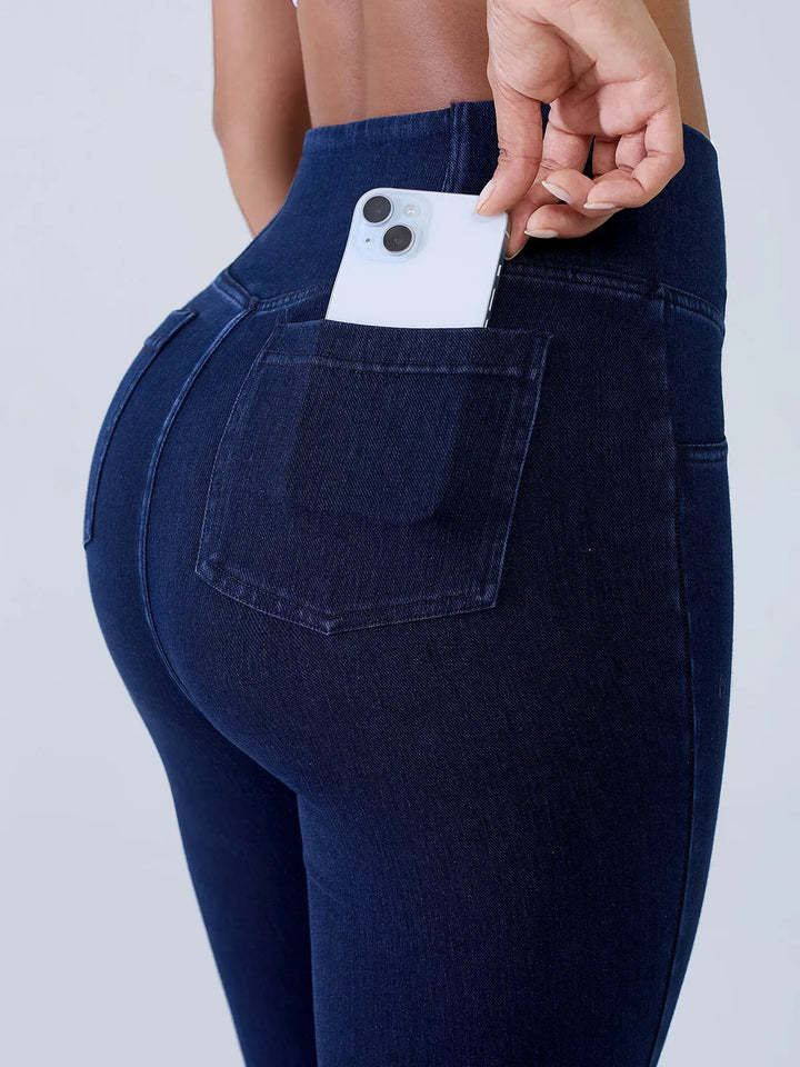 A model wearing a BRXL® Crossover Denim Sculpting Leggings with Pockets in