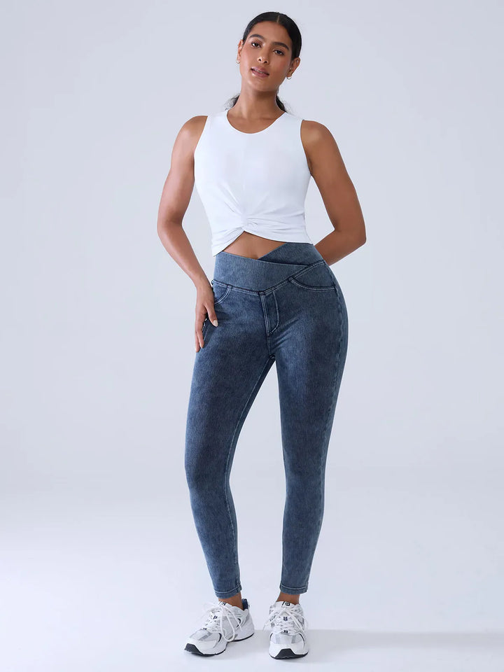 A model wearing a BRXL® Crossover Denim Sculpting Leggings with Pockets in