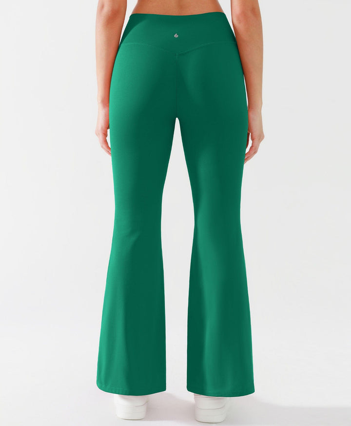 A model wearing a BRXL® Crossover Flared Yoga Pants in