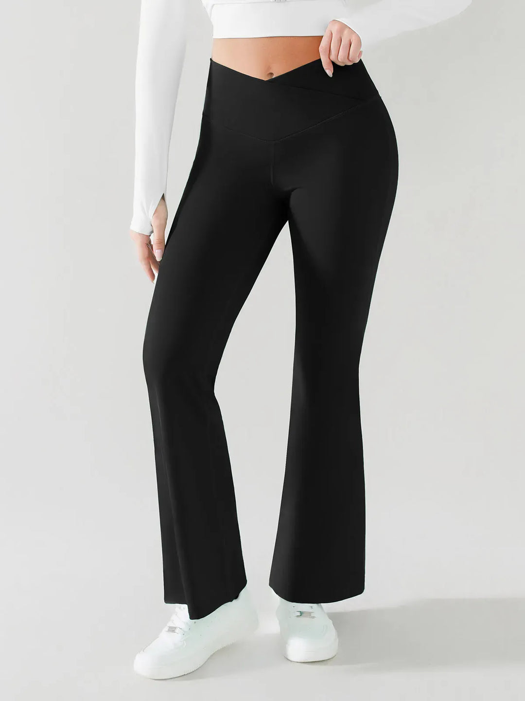 A model wearing a BRXL® Crossover Flared Yoga Pants in Black / XS