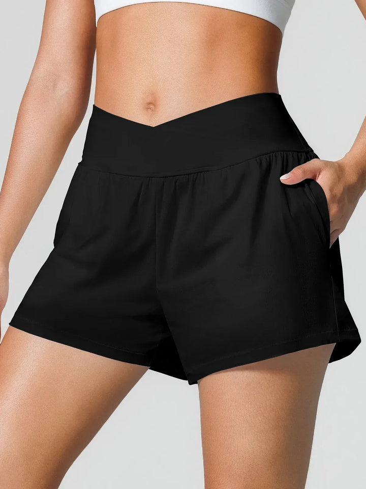 A model wearing a BRXL® Crossover Ruffled Flowy Shorts in Black / XS