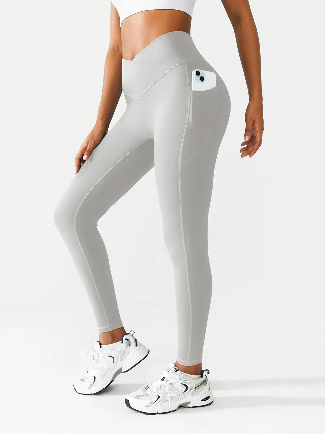 A model wearing a BRXL® Crossover Running Leggings with Pockets in