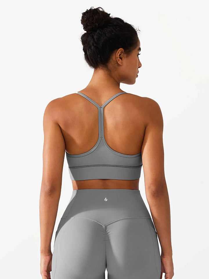 A model wearing a BRXL® Flow Y Racerback Bra with Low Cut and Spaghetti Straps in