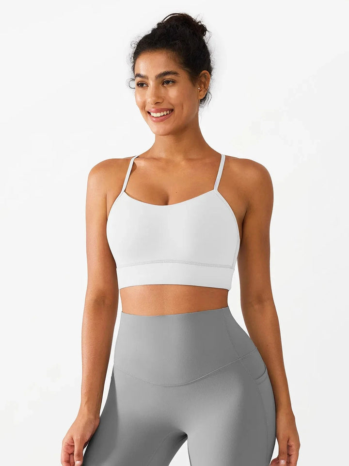 A model wearing a BRXL® Flow Y Racerback Bra with Low Cut and Spaghetti Straps in White / XS