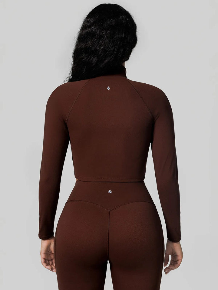 A model wearing a BRXL® Half Front Zipper Cropped Top Side Pockets Fleece Lined Leggings Set in