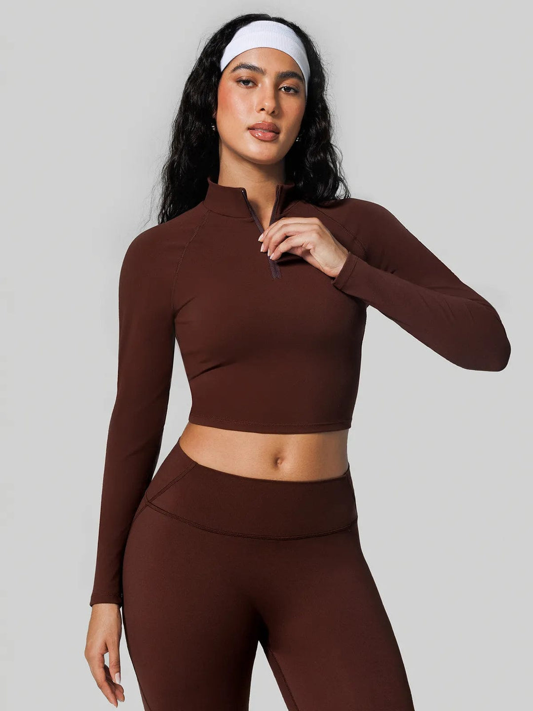 A model wearing a BRXL® Half Front Zipper Cropped Top Side Pockets Fleece Lined Leggings Set in