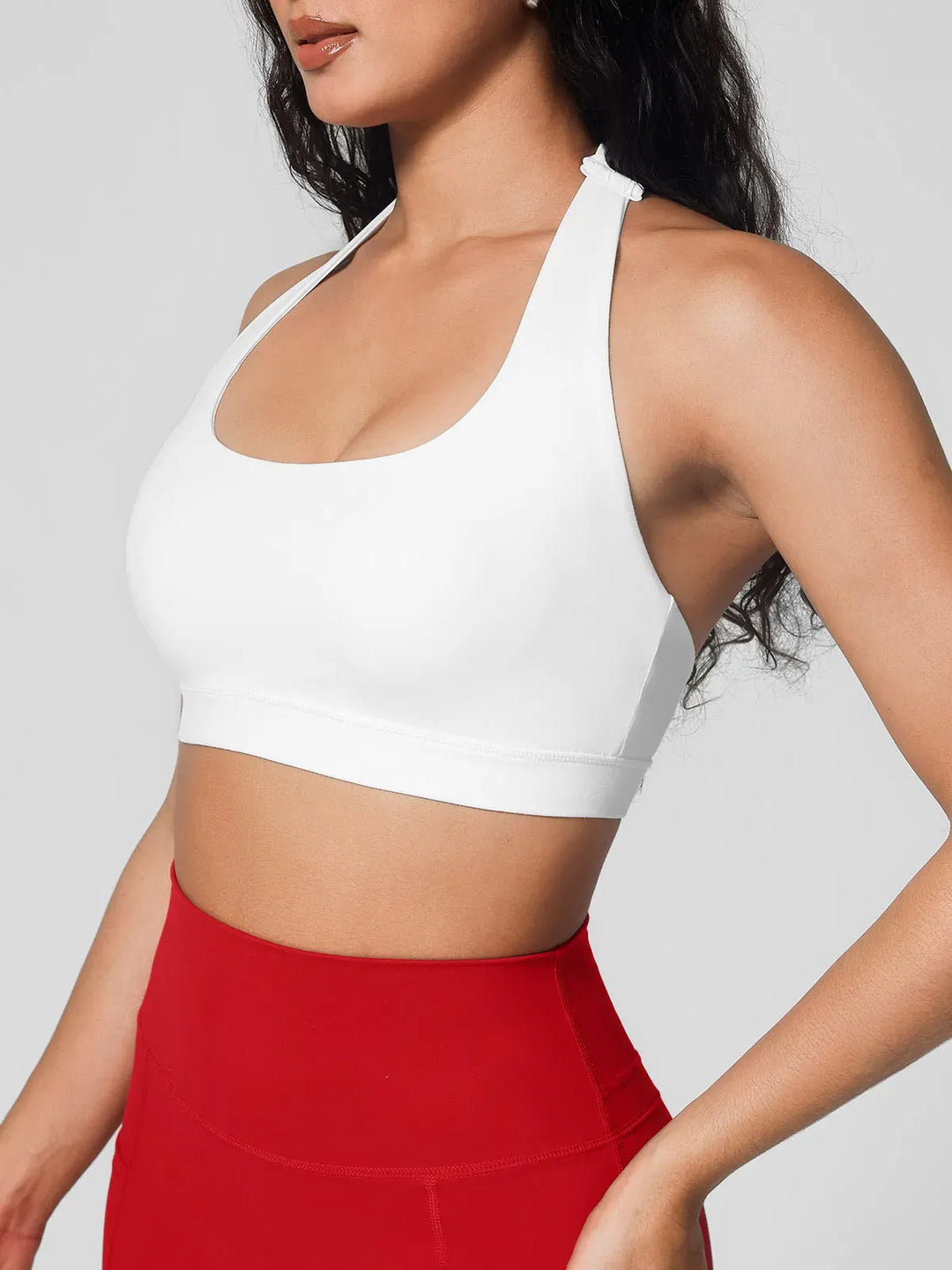 A model wearing a BRXL® Halter-neck Yoga Bra in White / XS