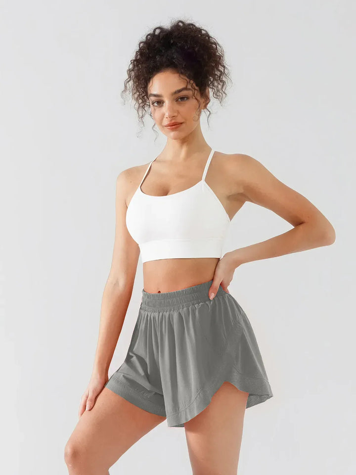 A model wearing a BRXL® High Waisted Butterfly Split Running Shorts in