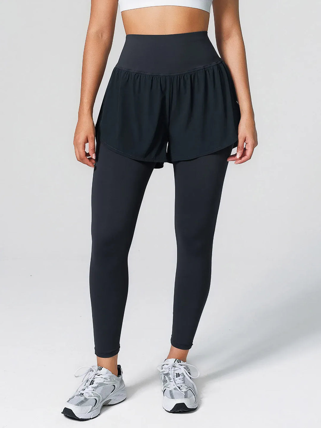 A model wearing a BRXL® Layered Combo Short Leggings in Navy Blue / XS