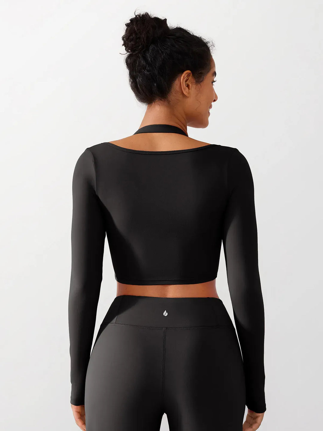 A model wearing a BRXL® Long Sleeve Halter Shrug Top with Buckle and Thumbhole in