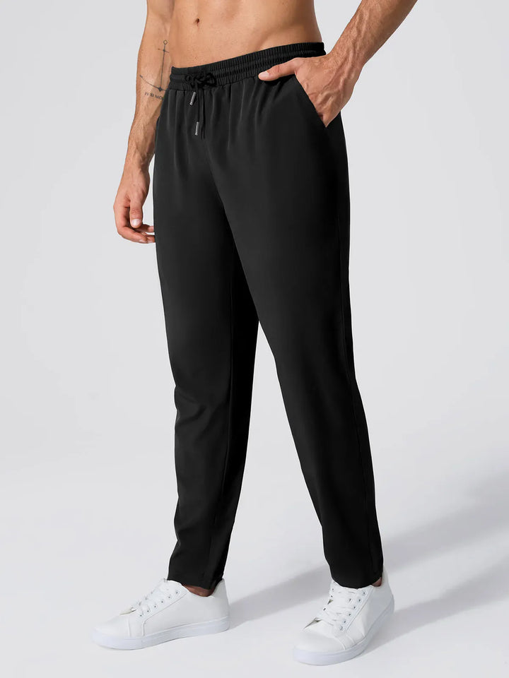 A model wearing a BRXL® Men’s  Adjustable Waist Tapered Activewear Joggers in Black / S