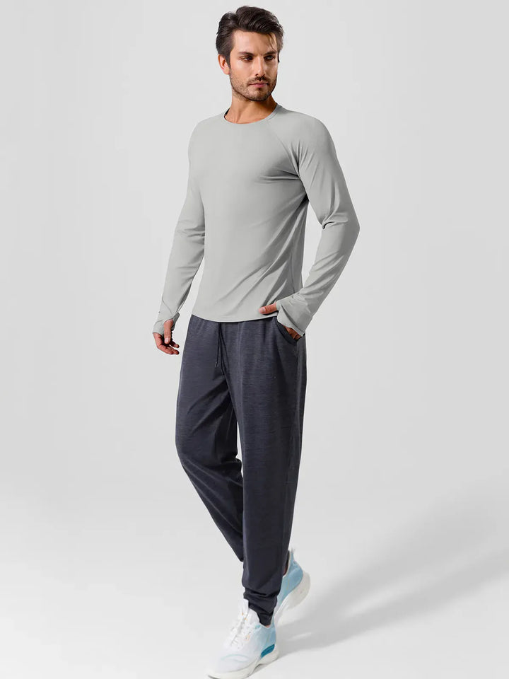 A model wearing a BRXL® Men’s Long Sleeve Thumbhole Activewear Shirt in