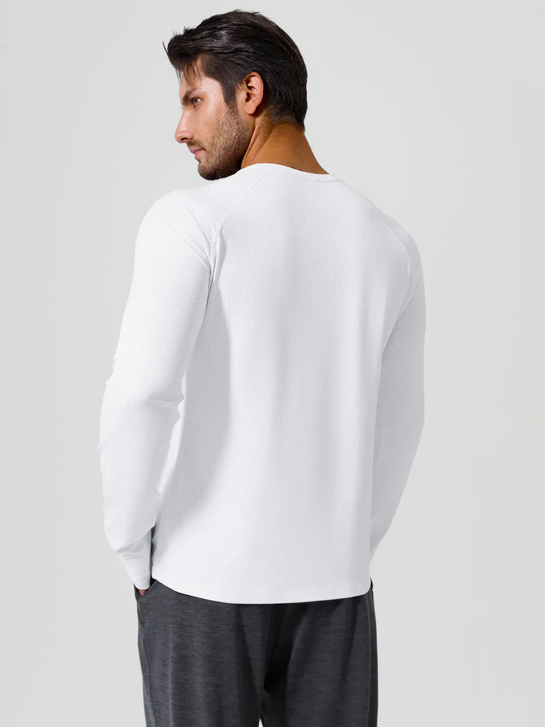 A model wearing a BRXL® Men’s Long Sleeve Thumbhole Activewear Shirt in