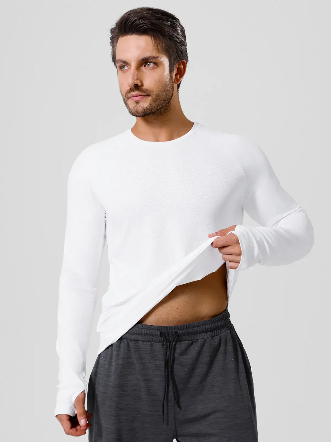 A model wearing a BRXL® Men’s Long Sleeve Thumbhole Activewear Shirt in