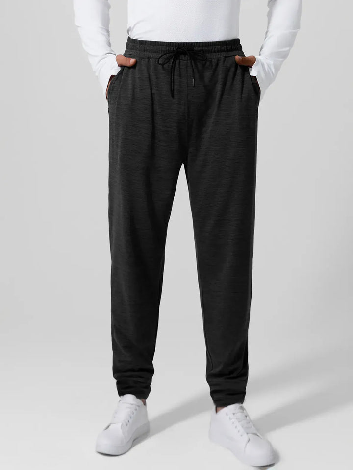 A model wearing a BRXL® Men’s Smooth Four Pockets Tapered Joggers in Black / S