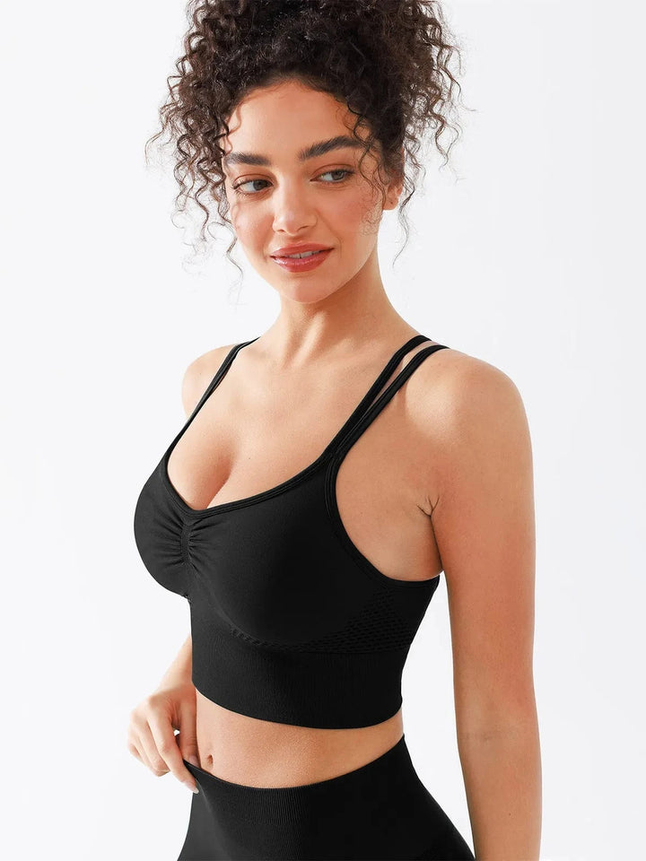 A model wearing a BRXL® Seamless Criss Cross Spaghetti Racerback Sports Bra in Black / XS