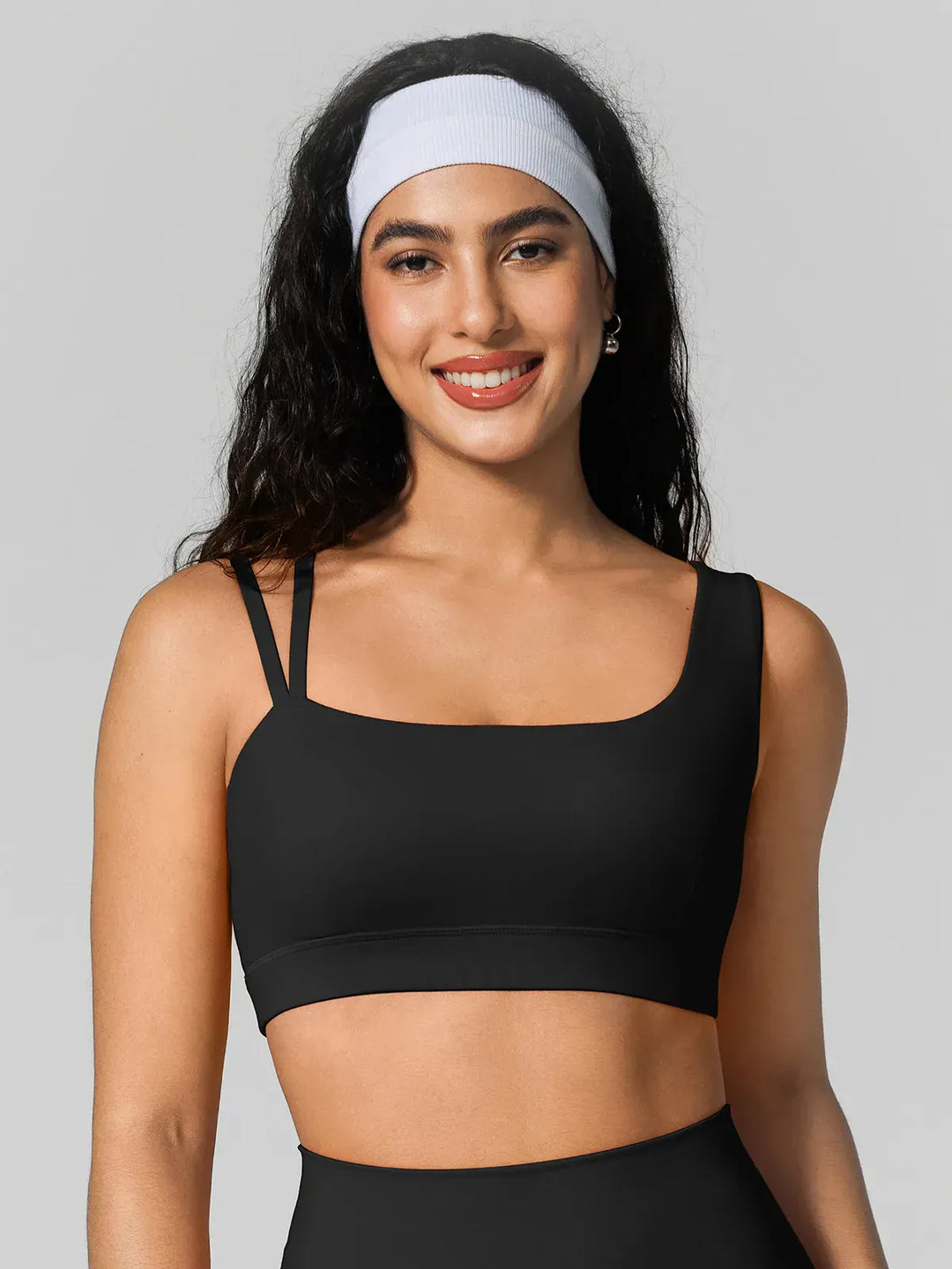 A model wearing a BRXL® Seamless Dual Style Square Neckline Sports Bra in Black / XS