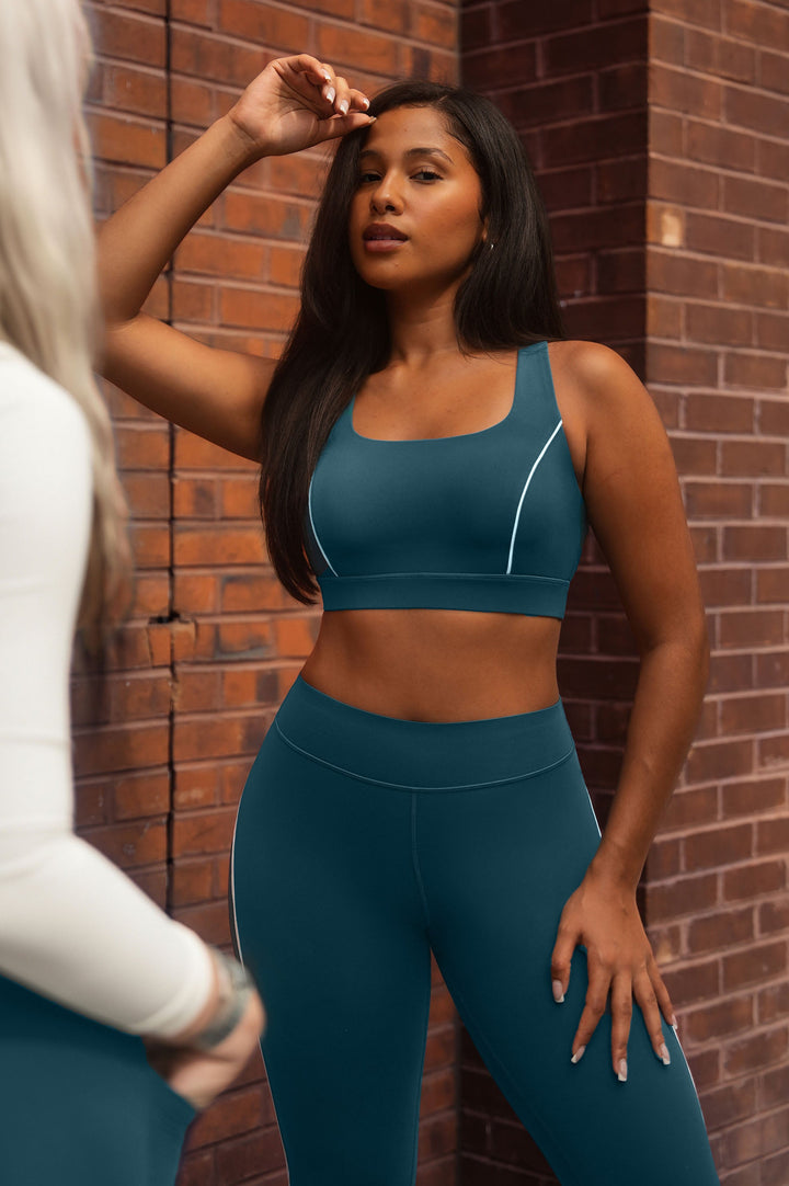 Blue sports bra by BRXL worn by a woman with matching shorts outdoors img