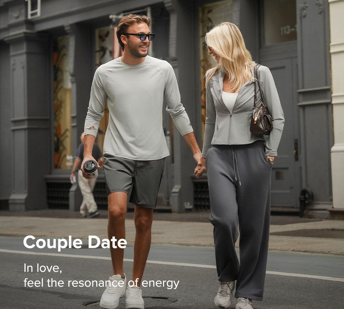 Man and woman walking together on a city street, holding hands.