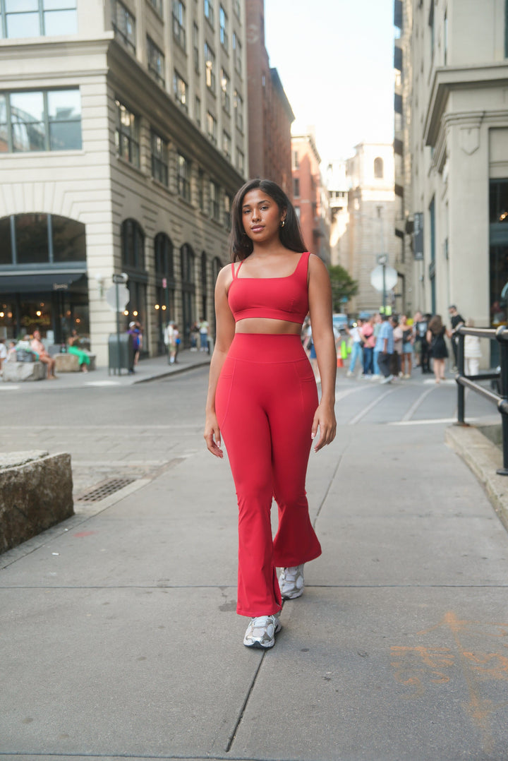 Woman in a red outfit walking on a city street