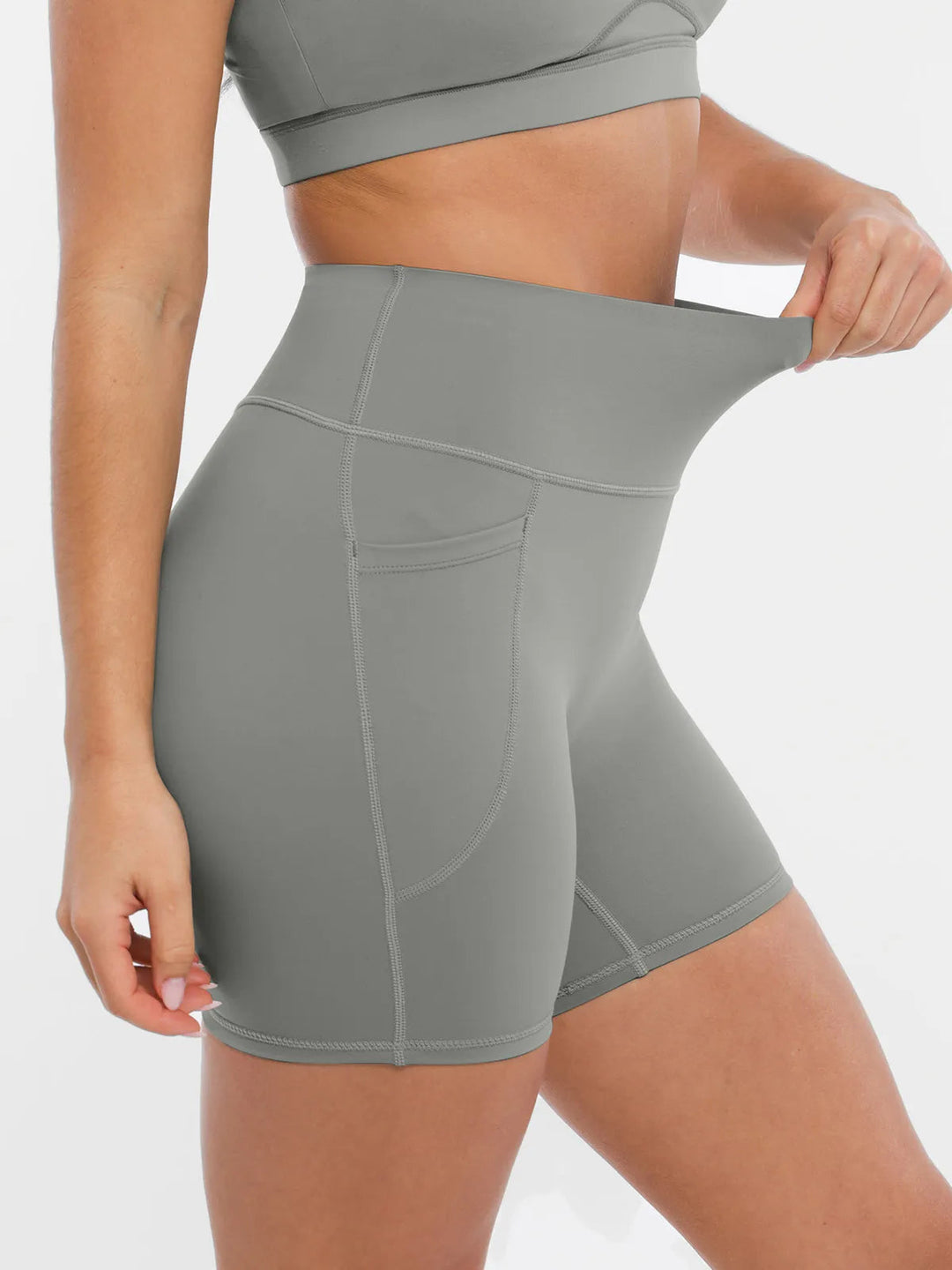 Model showing the elasticity of the BRXL gray biker shorts.