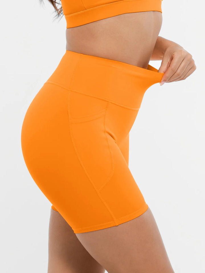 Model showing the elasticity of the BRXL orange biker shorts.