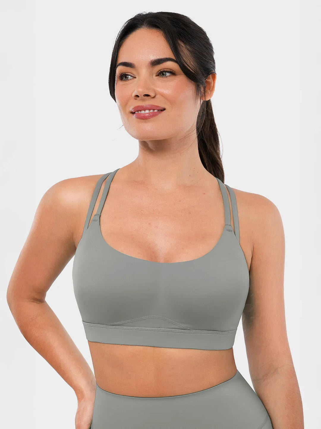 A woman is wearing a BRXL gray sports bra.
