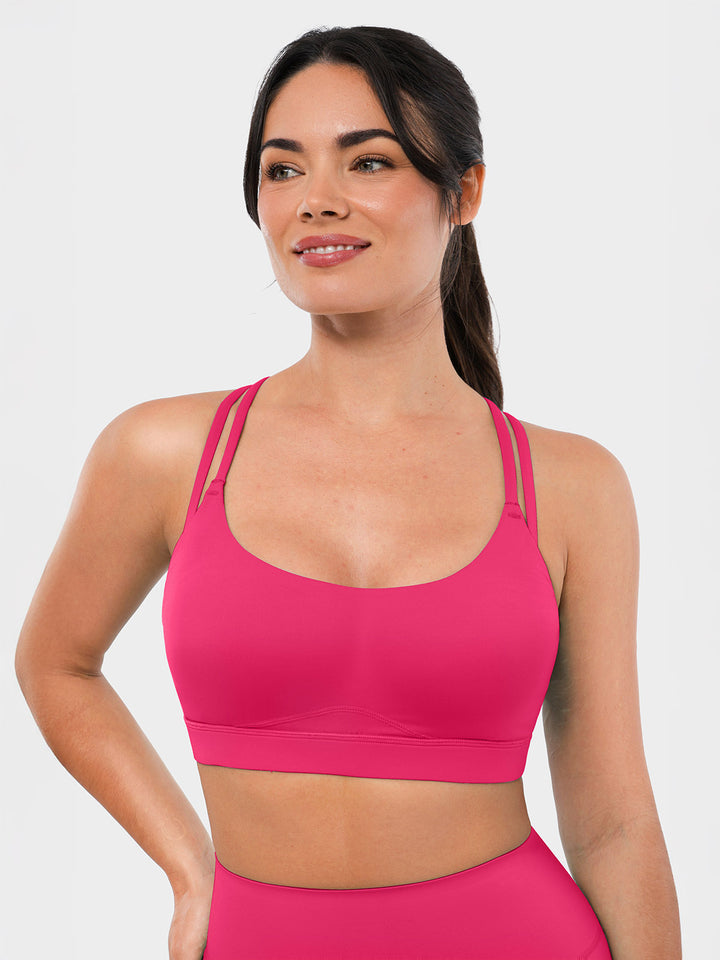 A woman is wearing a BRXL pink sports bra.