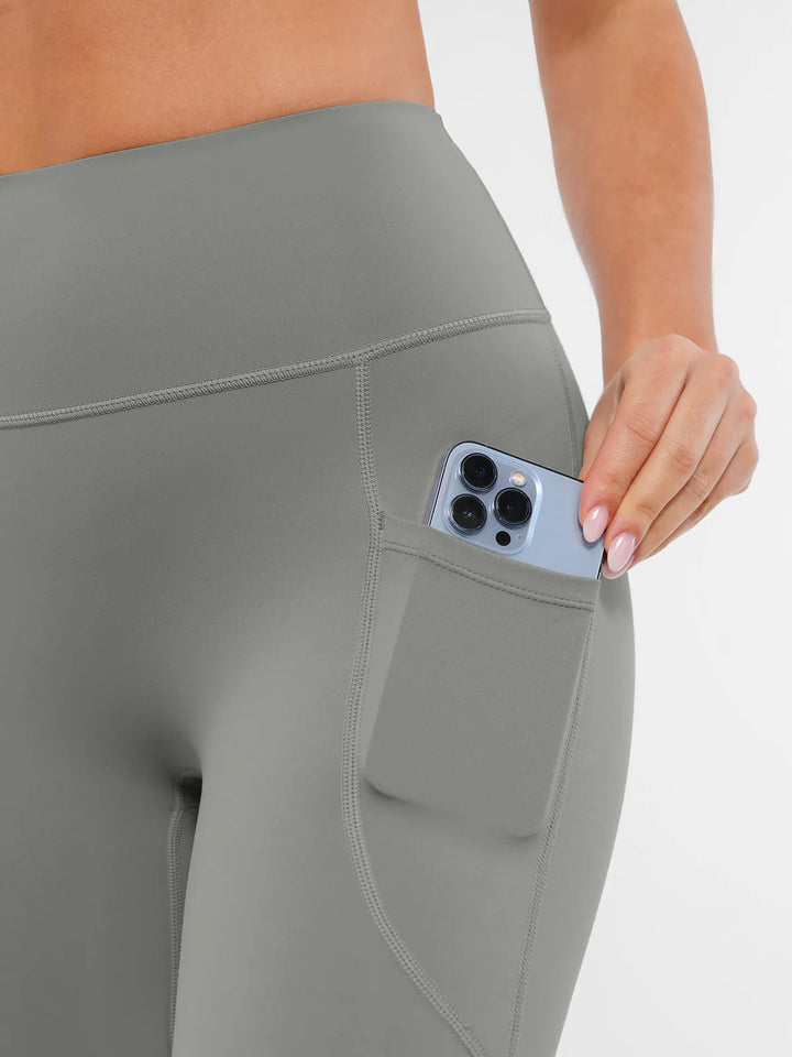 BRXL gray leggings with a pocket holding a phone.