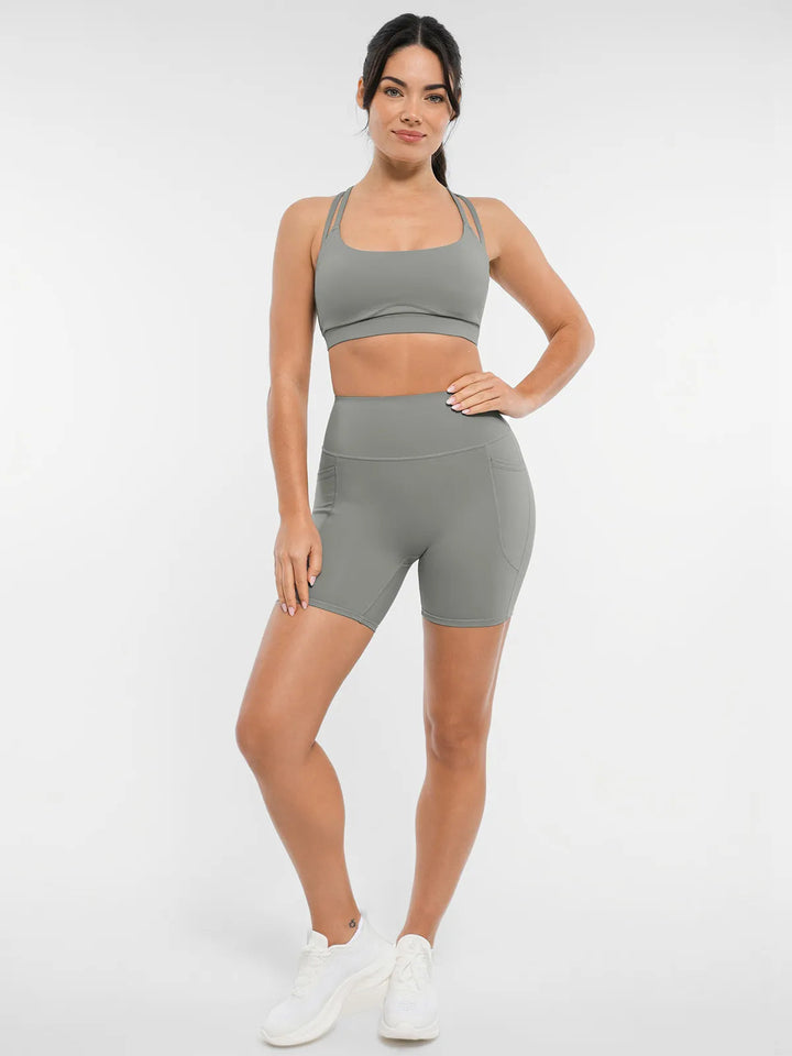 Woman wearing a gray biker shorts and sports bra.