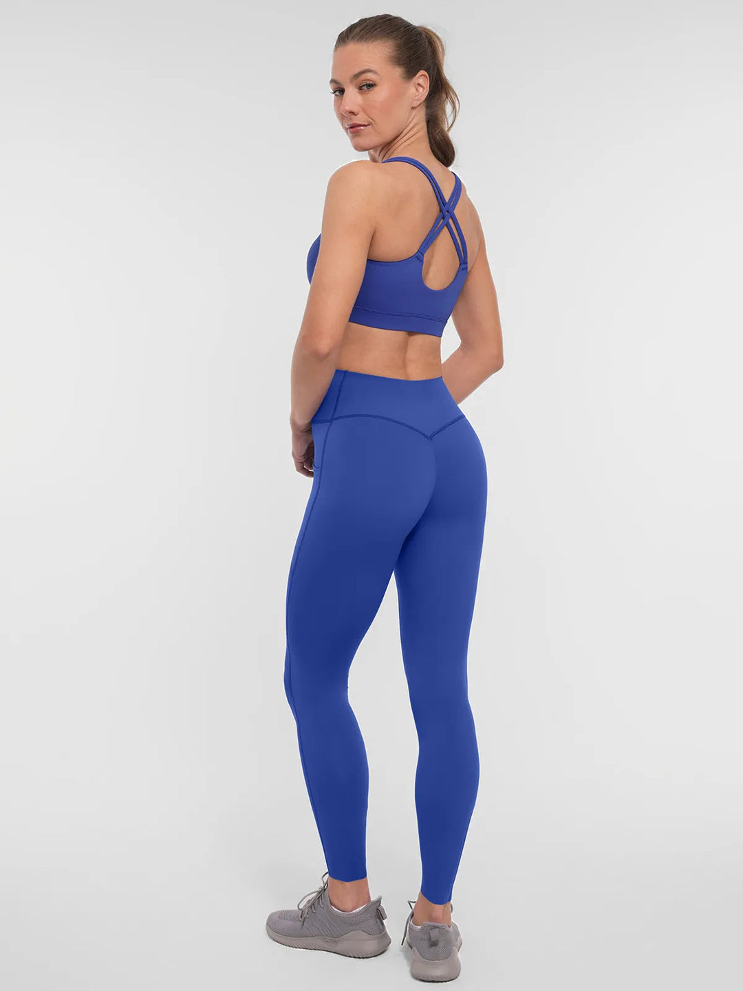 Woman wearing a BRXL blue leggings and sports bra.
