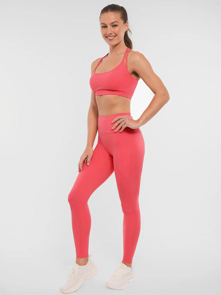 Woman wearing a BRXL coral leggings and sports bra.