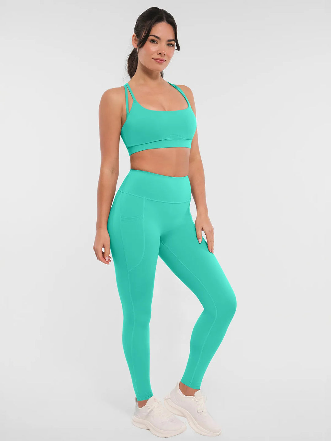 Woman wearing a BRXL mint green leggings and sports bra.