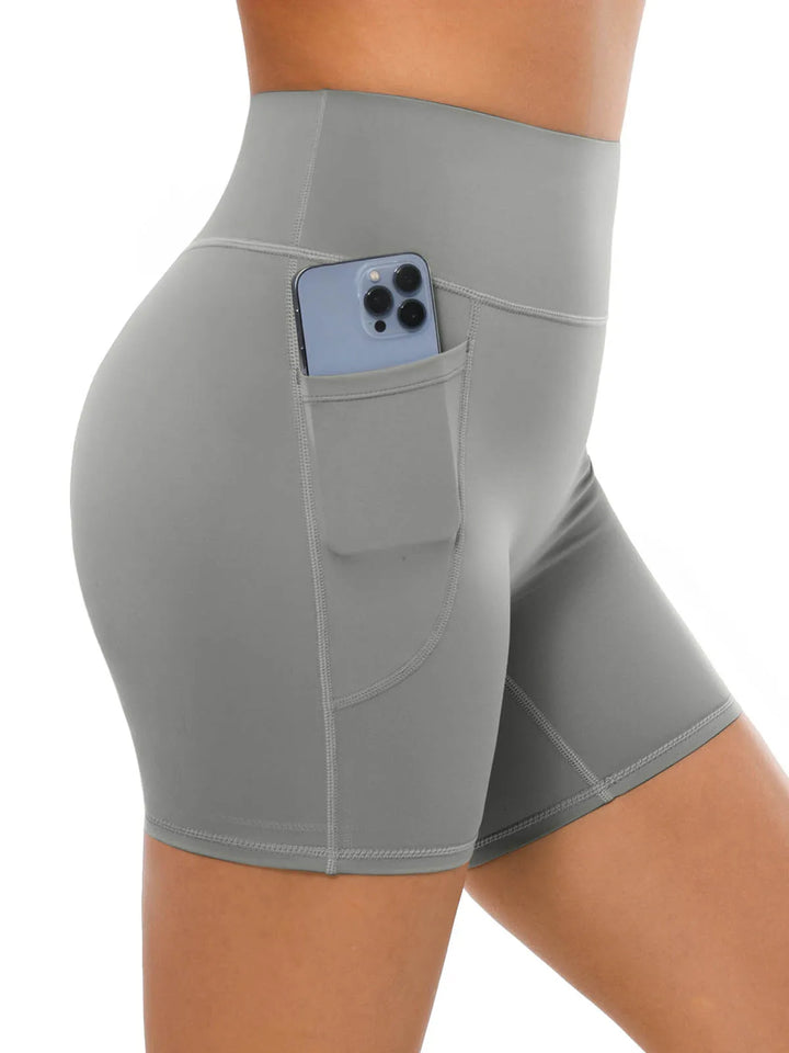 A model wearing high waisted gray biker shorts with a side pocket.