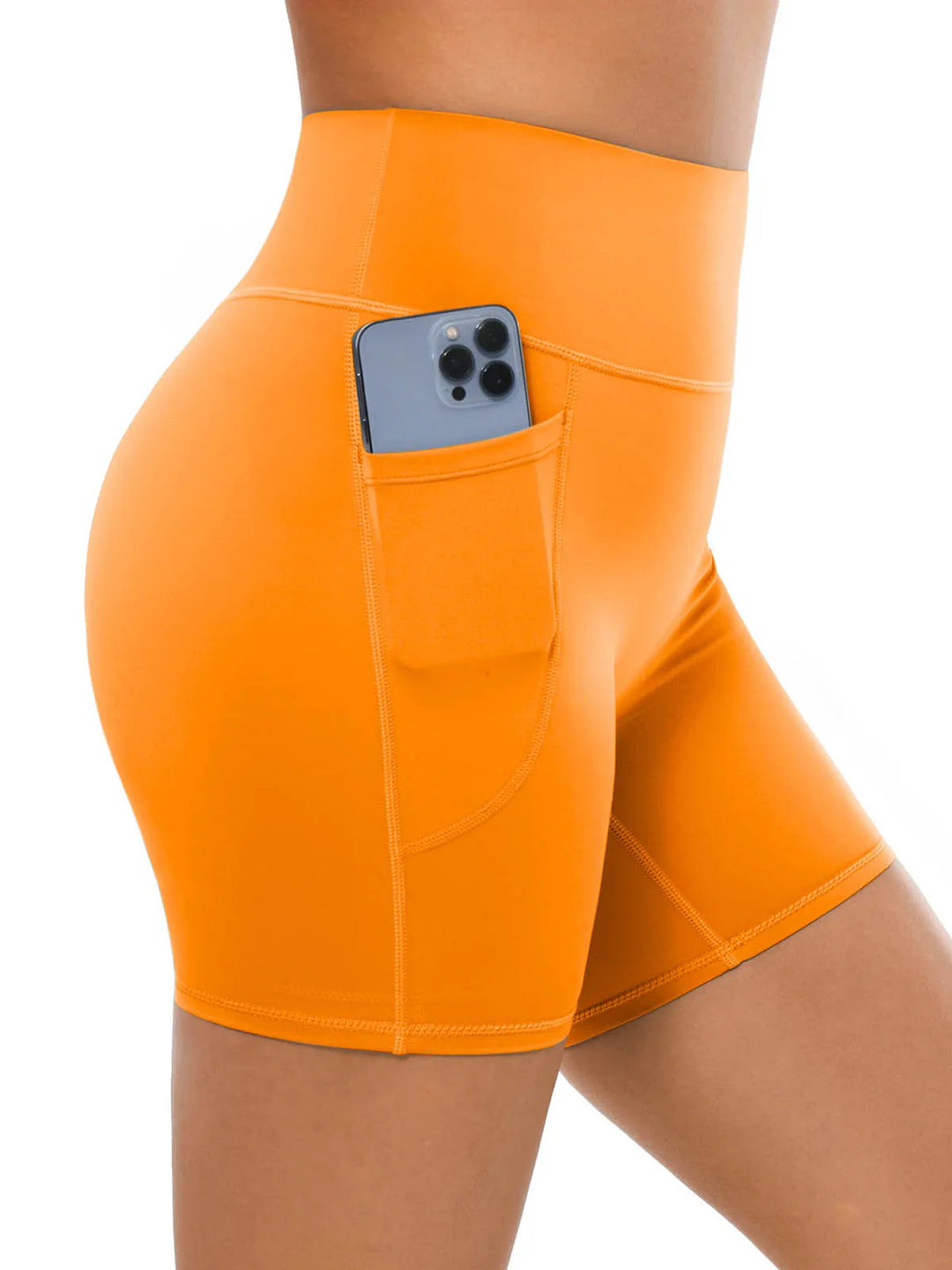 A model wearing high waisted orange biker shorts with a side pocket.