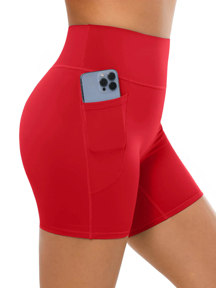 A model wearing high waisted red biker shorts with a side pocket.