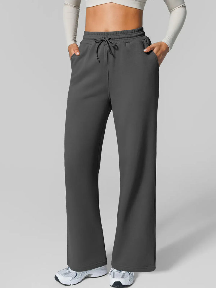 A model wearing a BRXL® Athleisure Drawstring Waist  Wide Leg Sweatpants in Dark Gray / XS