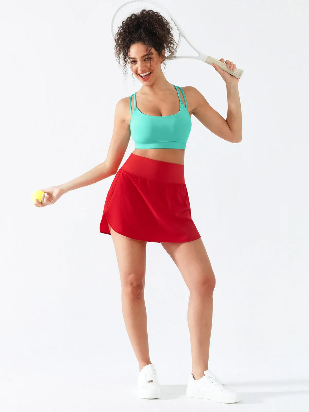A model wearing a BRXL® Athletic High Waist Interior Pocket Tennis Skirt in