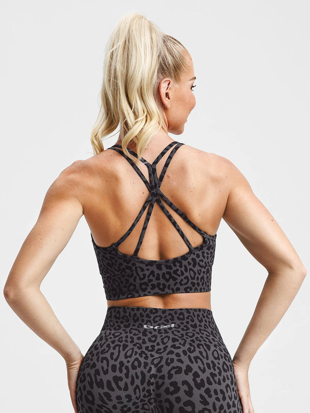 A model wearing a BRXL® B R X L® Seamless Criss Cross Spaghetti Racerback Sports Bra