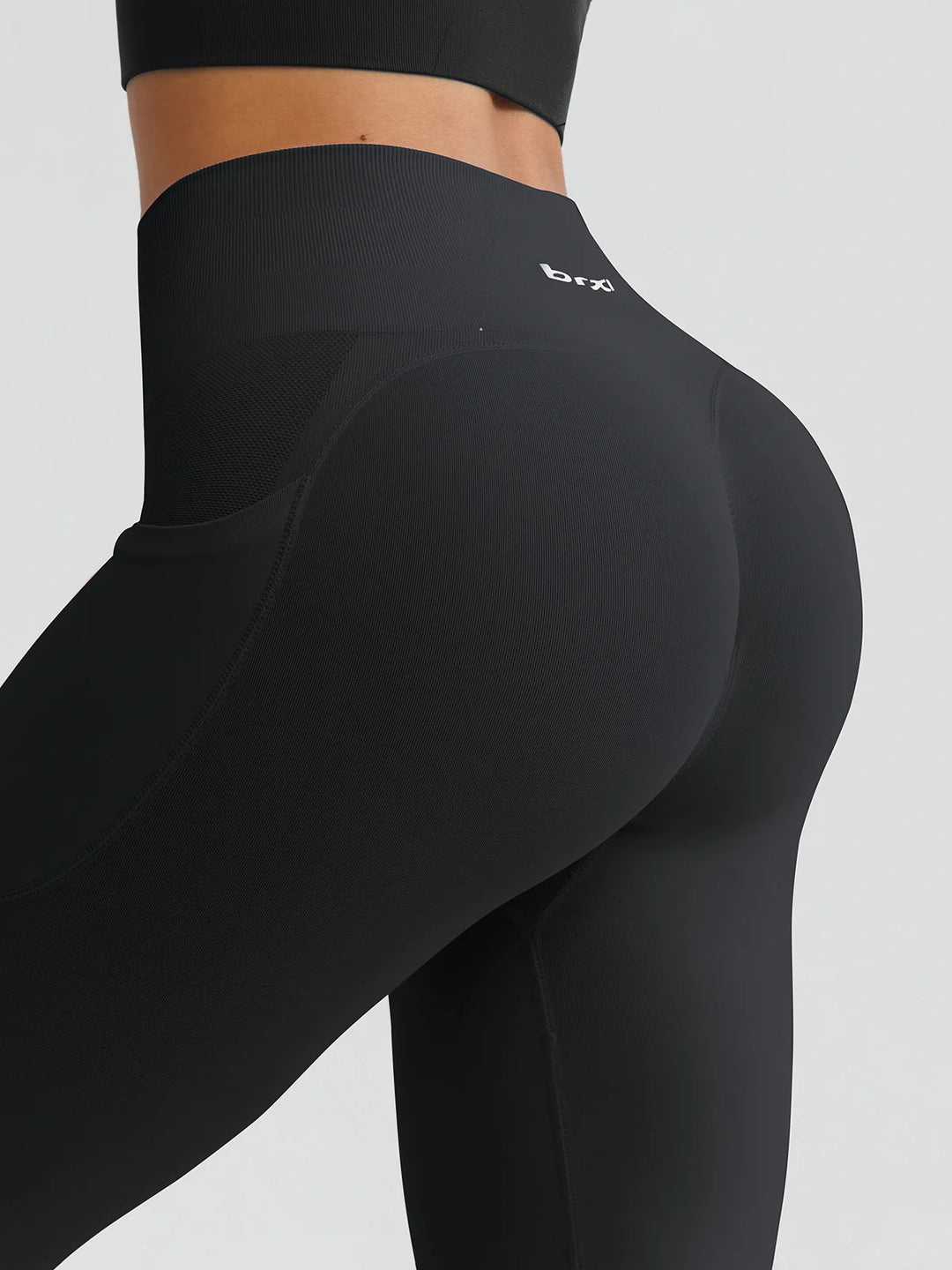 A model wearing a BRXL® B R X L™ Seamless High Waisted Butt-Lifting Leggings with Pockets